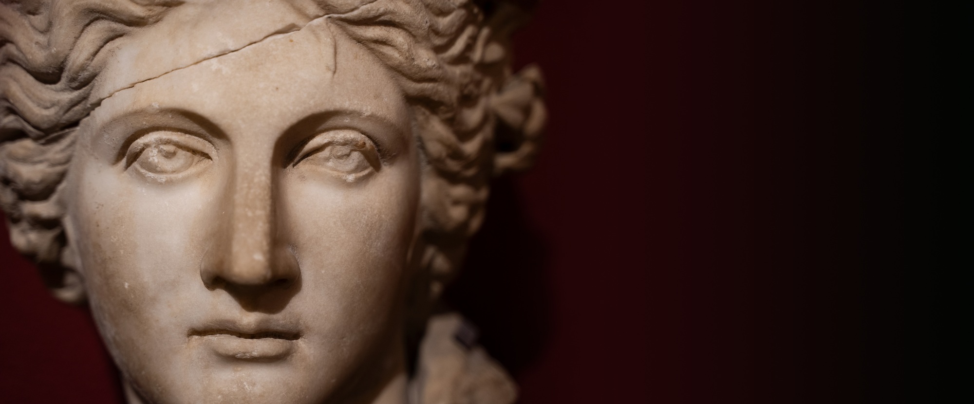 closeup of woman antique statue face on dark background