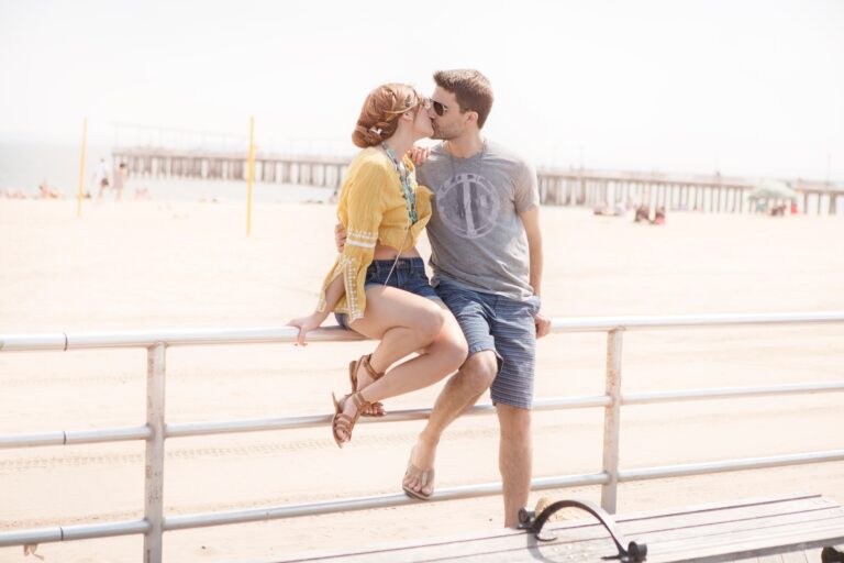 Couple on railings by beach kissing, Coney island, Brooklyn, New York, USA