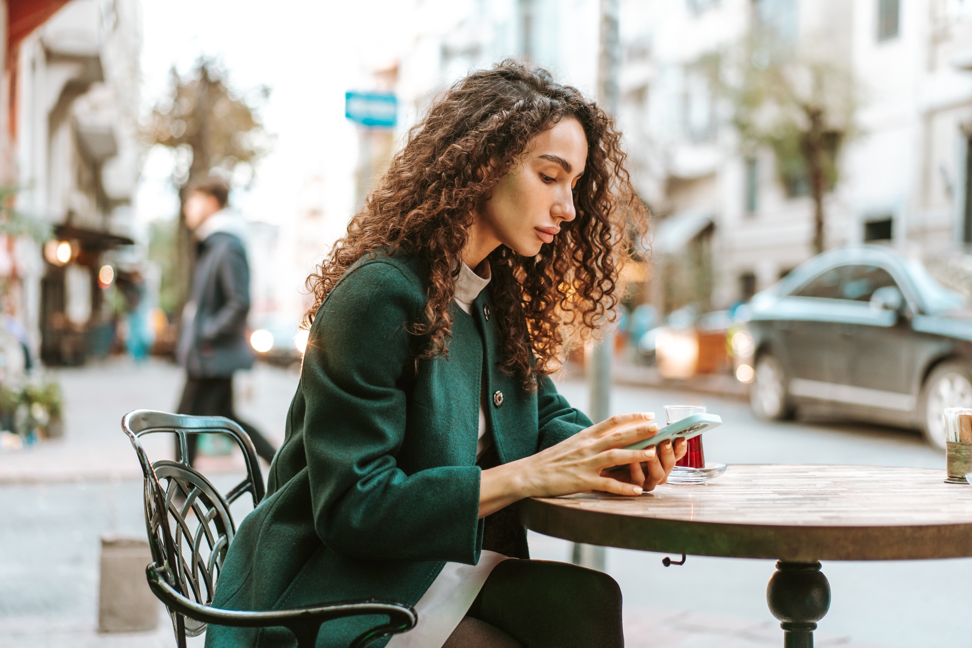 Young woman in a cafe reading a message from her mobile phone